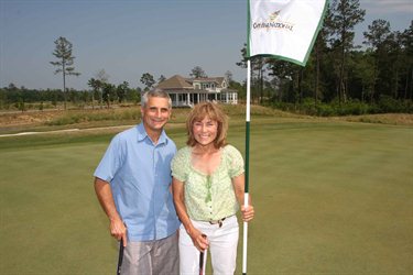 Sandy and Heidi Ergas standing on the green at Cape Fear National